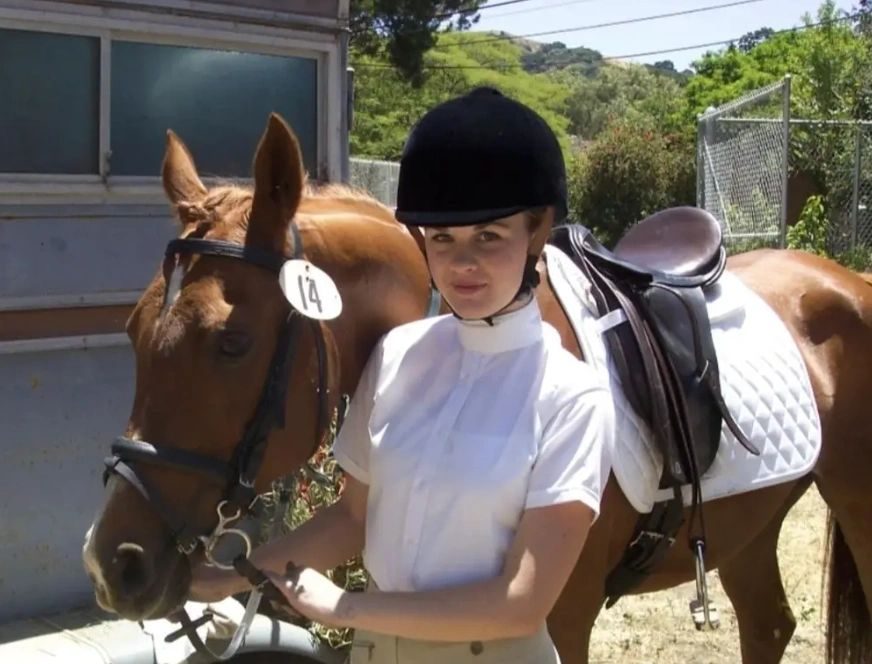 Brittany in riding gear with her horse